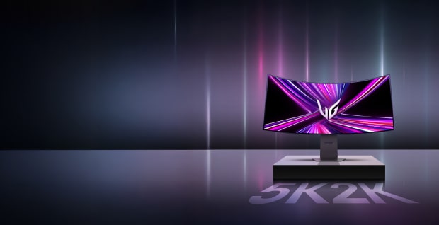 Bild av en bildskärm på en piedestal med texten 2K5K, huvudsakligen svart bakgrund med några vertikala strömmar av LED-ljus.